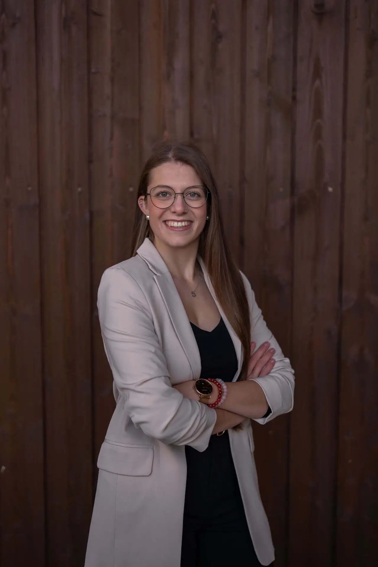 Karin Gadient, Mental Coach bei selbstbistdu.ch, lächelnd vor einem Holz-Hintergrund, bereit, Menschen auf ihrem Weg zu mentaler Stärke zu begleiten.